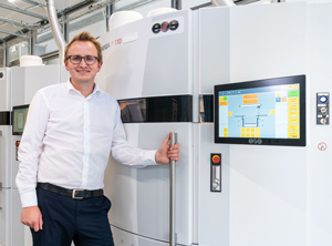 Tom Krause, Geschäftsbereichsleiter Additive Fertigung, vor dem neuen SLS-Gerät (Foto: Igus)