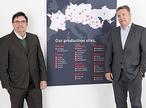 Christian Winter (re.) und Christian Grimm vor einer Karte mit den Produktionsstandorten von Hirsch Servo (Foto: Hirsch Porozell)