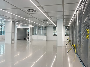 Die 320 m² große Erweiterung des modularen Reinraumsystems wurde während des Aufbaus mit einer Staubschutzwand von der laufenden Produktion getrennt (Foto: Schiller Engineering)